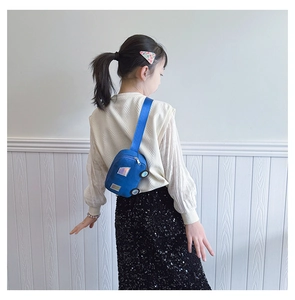 Rear view of a child wearing a blue car-shaped canvas chest bag with adjustable strap