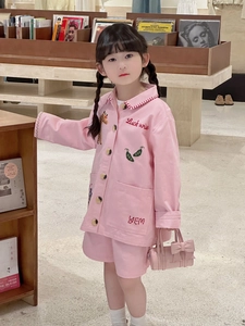 Detail of pink girls' jacket with embroidered patches and matching bow handbag accessory