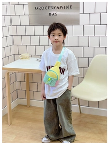 Détail d'un sac de poitrine pour enfant coloré avec panneaux contrastés et poche à cordon