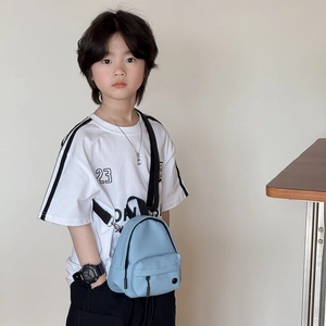 Mini sac bandoulière bleu ciel pour enfant avec poche zippée porté par un modèle