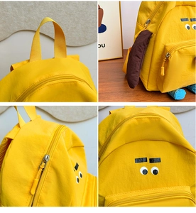 Dettagli dello zaino giallo a forma di cane con cerniera e tessuto in nylon impermeabile
