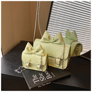 Détail de mini sacs bandoulière vert menthe avec nœuds décoratifs et boucles en métal