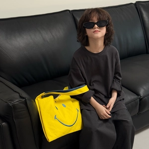 Cute yellow canvas shoulder bag with large blue smiley face for trendy kids fashion