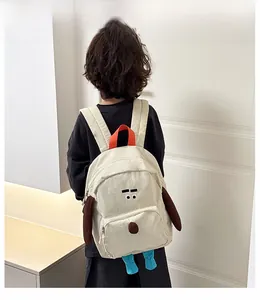 Dettaglio di un bambino con zaino in tela a forma di cagnolino con orecchie 3D colorate