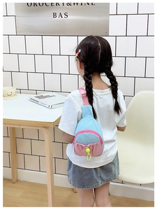 Détail du sac de poitrine enfant contrasté bleu et rose avec cordon jaune et sangle réglable