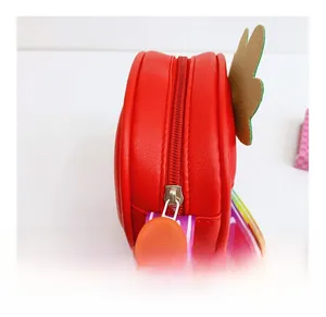 Close-up of strawberry kid's purse showing smooth red metal zipper and woven shoulder strap