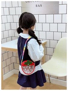Close-up of strawberry child bag with colorful sequins and rainbow strap details