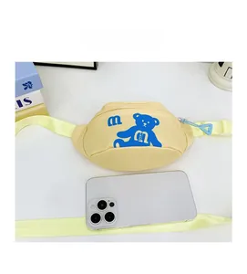 Cute yellow kid's chest bag with blue bear print shown next to a phone for size reference