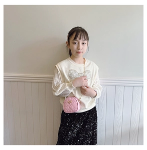Mini sac matelassé rose en forme de cœur avec chaîne dorée sur un mannequin enfant