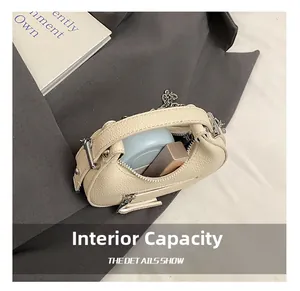 Detail showing internal capacity of the mini cream leather bag with silver chain
