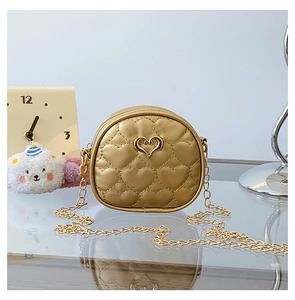 Détail du sac doré pour fille avec matelassage en cœur et bandoulière chaîne