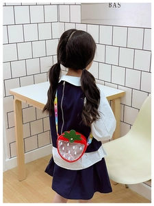 Cute strawberry crossbody bag for kids featuring sequins and a colorful woven strap