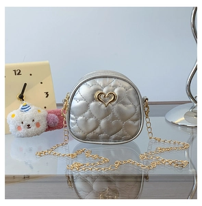 Détail du mini sac matelassé cœur argenté avec breloque cœur dorée et bandoulière