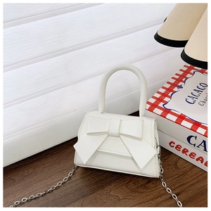 Detailed view of a white mini princess handbag with bow decor and silver chain strap