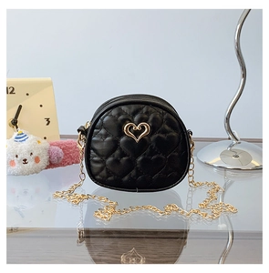 Détail du mini sac matelassé cœur avec chaîne dorée et logo métallique en cœur