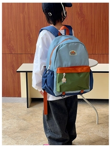 Rear view of child wearing the colorful patchwork backpack with blue and green panels