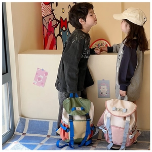 Detail of color-block canvas backpacks with adjustable straps and buckle closures for kids