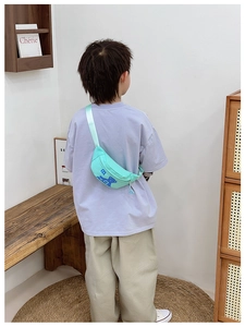 Rear view of a child wearing a light green cartoon bear waist bag with adjustable strap