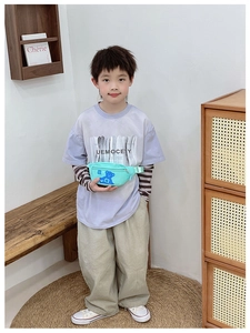 Detailed view of mint green kids chest bag featuring a blue bear print on a model