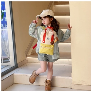 Détail d'un sac à dos enfant en toile color-block avec un joli charm de chien brun