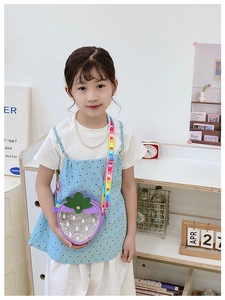 Close-up of strawberry shape kids bag with purple glitter and rainbow strap details