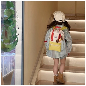 Vue arrière d'un enfant portant le sac à dos en toile contrastée avec pendentif ours
