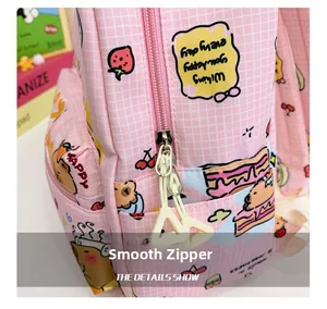 Detail of a pink checkered backpack showing a smooth zipper with a yellow pendant