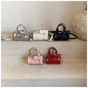 Mini cylinder bags for girls in five colors featuring large decorative bows and handles