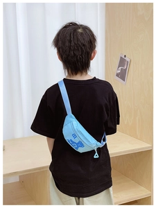 Detail of light blue kids chest bag with cartoon bear print on an adjustable strap