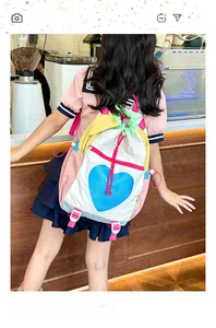 Detail of color-block backpack featuring blue heart print and drawstring closure in a cafe