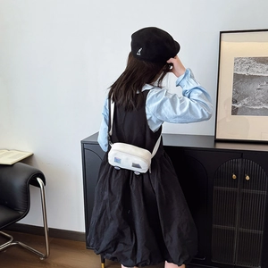 Cute white car-shaped canvas chest bag for kids shown in a minimalist home setting