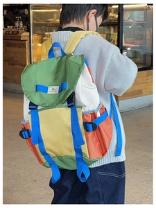 Detail of multi-color nylon backpack with adjustable blue straps and secure buckles