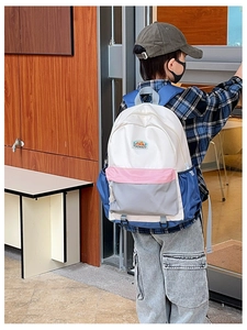 Outdoor shot of a student backpack featuring a stylish four-color patchwork nylon design