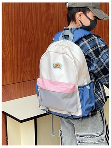 Side view of multi-color patchwork backpack with large main pocket and water bottle holders