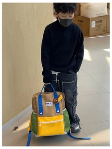 Détail du sac à dos enfant bicolore avec sangles bleues et poche avant jaune vif