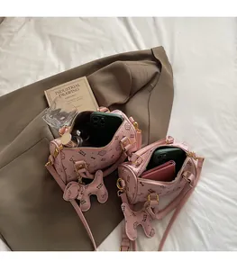Pink kitten print cylinder handbag showing interior capacity for wallet and smartphone