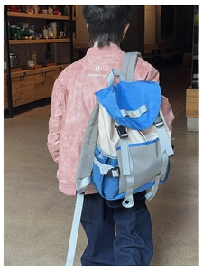 Close-up of a child wearing the blue and white color-block nylon backpack with drawstring