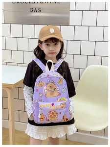 Detail of purple cartoon capybara school bag on a young girl in a cozy room