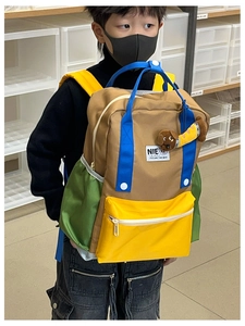 Détail du sac à dos enfant multicolore avec pendentif chien et poche avant jaune