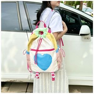 Close-up of heart pattern on a color-block backpack with drawstring and mesh detail