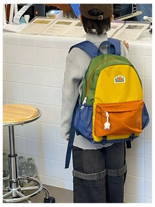 Rear view of a child wearing a colorful patchwork backpack with large capacity