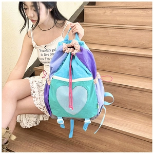 Close-up of a colorful patchwork backpack with a blue heart-shaped mesh pocket detail