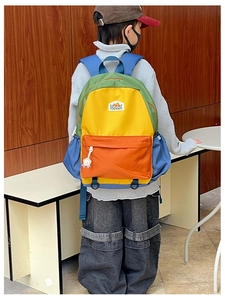 Detail of colorful patchwork school backpack featuring yellow and orange contrast design