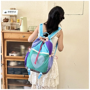 Detail of multi-color heart patchwork canvas backpack with drawstring closure and blue straps
