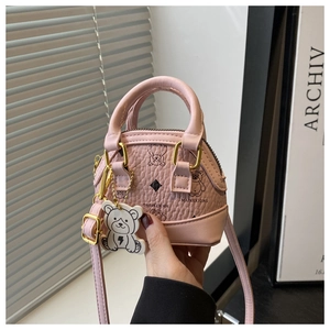 Close-up of pink mini shell bag with bear print, gold hardware, and bear keychain