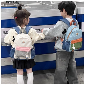 Rear view of children wearing colorful high-capacity school bags with a mountain logo