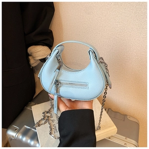 Macro shot of light blue lychee pattern leather mini bag with silver chain and metal zipper