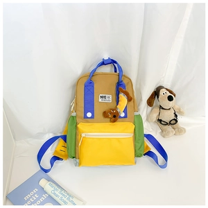 Détail d'un sac à dos enfant bicolore en toile kaki avec pendentif chien mignon