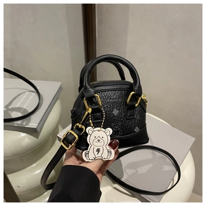Close-up of black crossbody bag with cute bear print and cartoon lightning charm