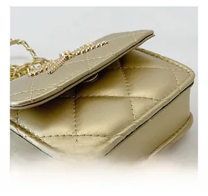 Detailed close-up showing quilted stitching and chain texture on a golden mini bag